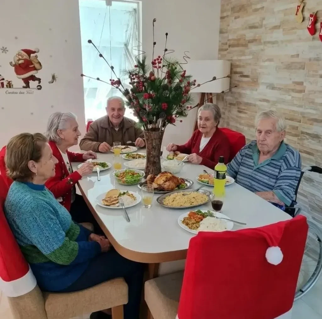 Idosos reunidos à mesa durante a ceia de Natal
