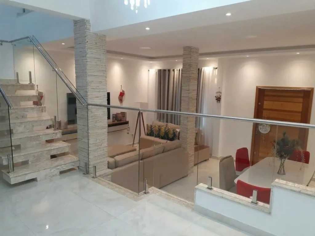 Hall de entrada com escada de mármore e guarda-corpo de vidro