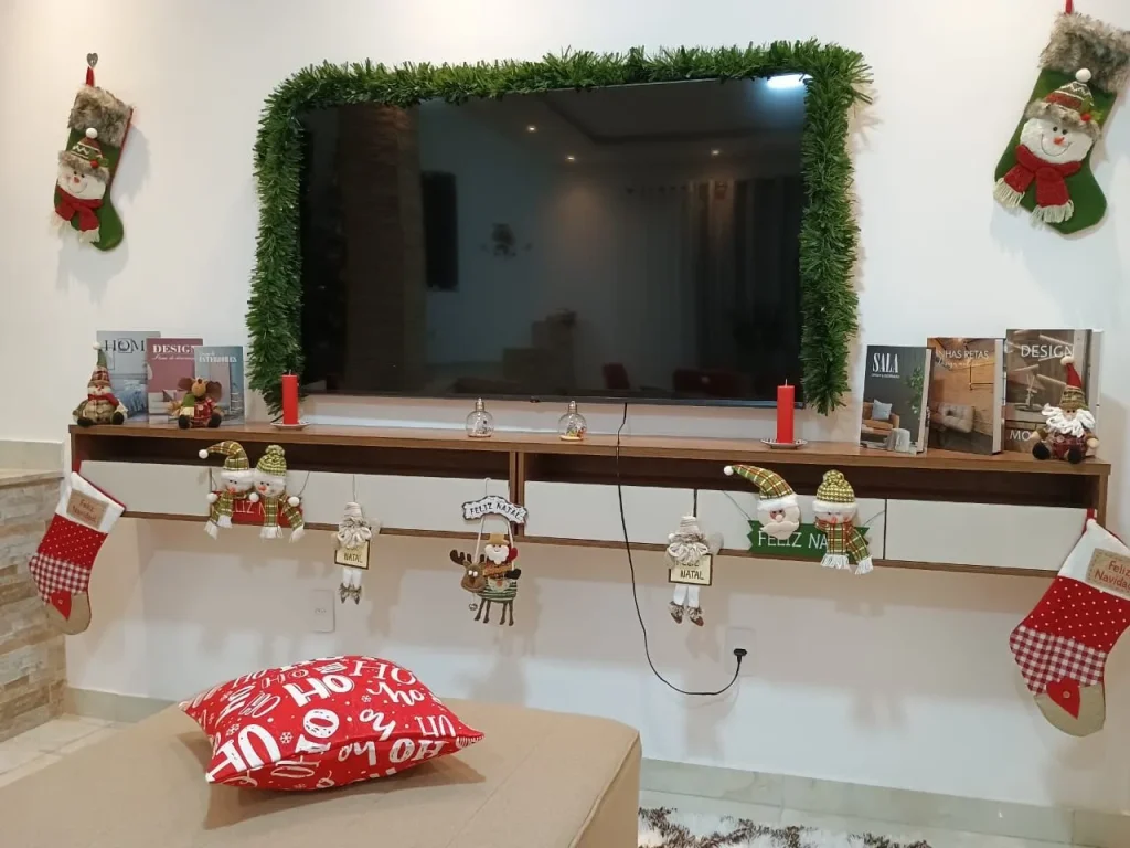 Painel de TV decorado com guirlanda e meias de Natal
