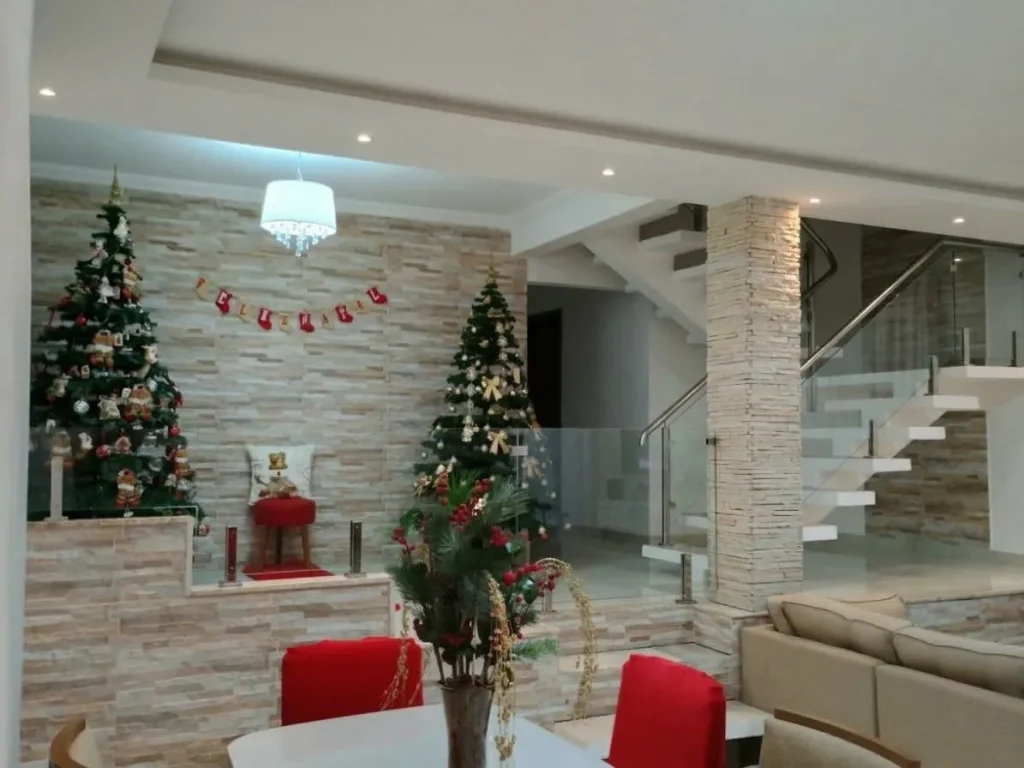 Sala com árvores de Natal ao lado da escada
