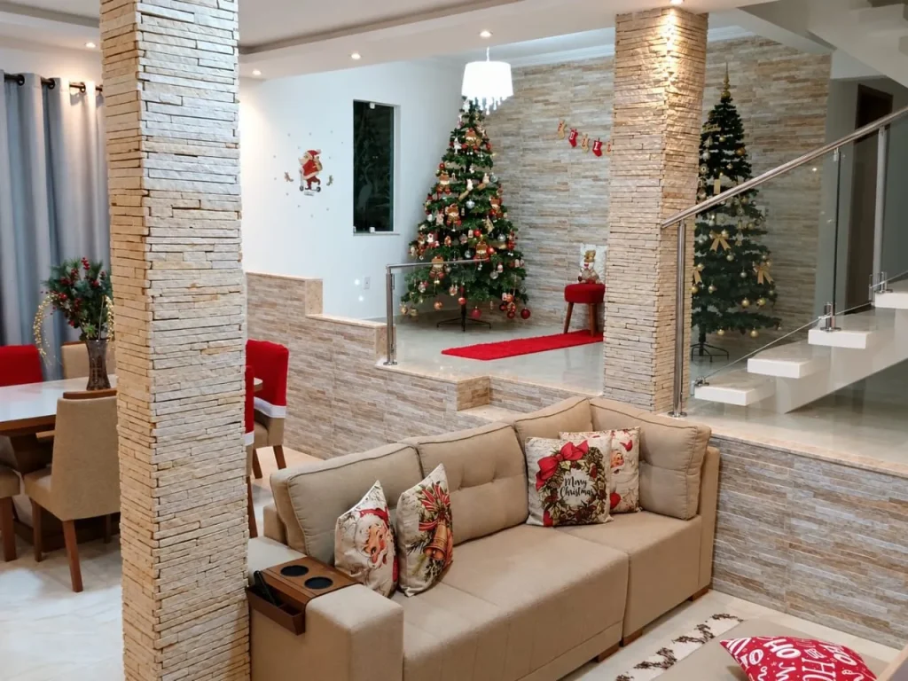 Sala com sofá, pilar de pedra e escada