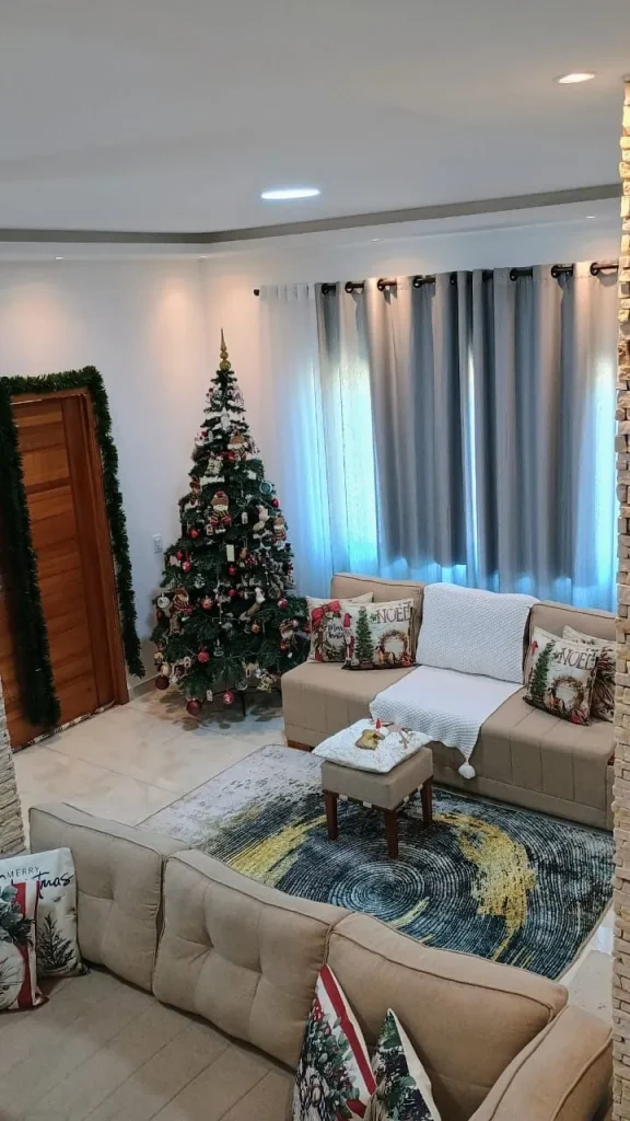 Sala com tapete, sofás e árvore de Natal