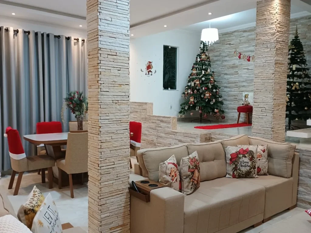 Sofás com almofadas e a mesa de jantar ao fundo